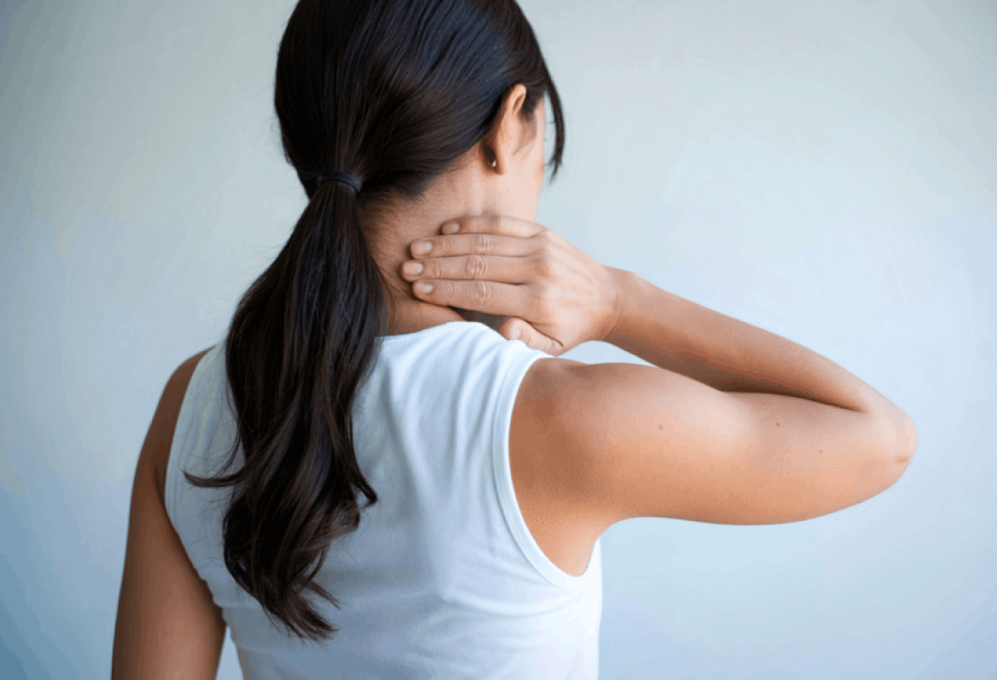 Woman seen from the back, hands wrapped around her neck as if in neck pain or discomfort. delayed-car-accident-injuries 1 | Gabrielson Law Offices, LTD delayed-car-accident-injuries 1 | Gabrielson Law Offices, LTD